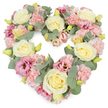 In the photograph, a soft yet luxurious heart-shaped floral wreath is set against a spotless white background, drawing attention to its soothing colours and intricate craftsmanship. The heart is evenly proportioned, with rounded shoulders and a gentle point, giving an immediate sense of comfort and devotion. Cream and pale yellow roses stand out as the key blooms, their velvety petals coiled in tight spirals at the centre and gradually opening into full, luminous flowers that catch the light. Between these roses lie generous clusters of pastel pink carnations, each blossom edged with delicate ruffles that create a rich, textured surface, like layers of fine lace. Threaded amidst them are dusky pink and mauve lisianthus flowers, some wide open, others in softer, partially unfurled forms, adding emotional depth and a slightly more intense note of colour that feels thoughtful rather than bold, akin to the peaceful evenings around Chalfont St Giles' ponds and lanes. Silvery-green eucalyptus sprigs weave through the wreath, their rounded leaves providing a gentle, cooling contrast and subtly shaping the heart's edges. Small yellow-green buds peek out between petals, suggesting freshness and meticulous, recent preparation by a florist who understands the importance of every detail in moments of grief. All the flowers are placed closely, leaving no visible gaps, resulting in a wreath that appears dense, generous, and carefully composed. This heart-shaped tribute would sit beautifully beside a casket, on a stand at a church in Chalfont St Giles, or at a crematorium service nearby, offering a quiet, floral expression of sympathy, remembrance, and enduring love when words feel hard to find.